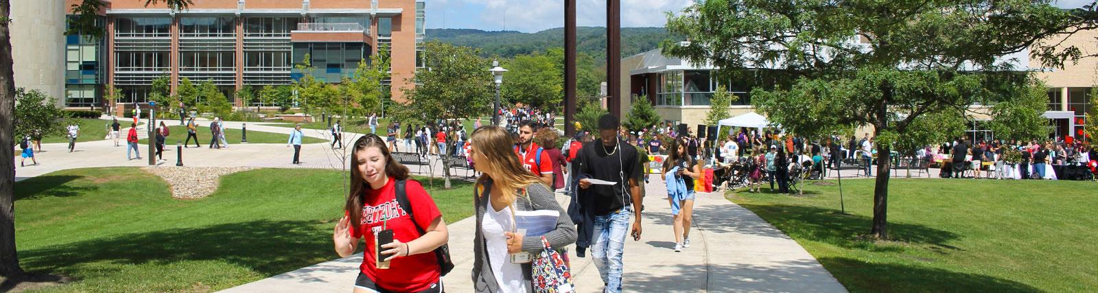 large group of students walking in quad near clocktower